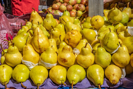 Abundance of Fresh Yellow Pears and Apples at an Outdoor Farmers Market Stall