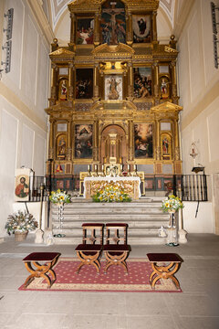 Golden retable in a Catholic church sanctuary with altar and pews