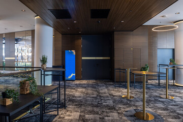 Naklejka premium Modern cocktail lounge interior with gold tables and stylish ring lights