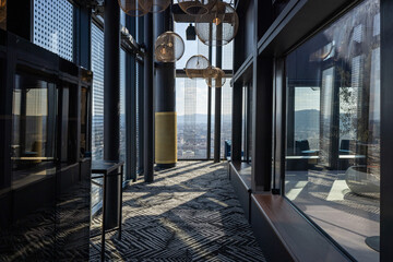 Naklejka premium Contemporary rooftop bar corridor with large windows and geometric patterned carpet