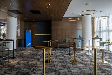 Naklejka premium Modern hotel lobby interior with elegant cocktail tables and contemporary lighting
