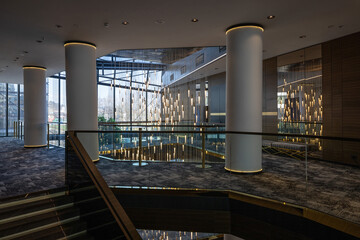 Naklejka premium Elegant hotel interior with large columns grand staircase and hanging crystal light installation