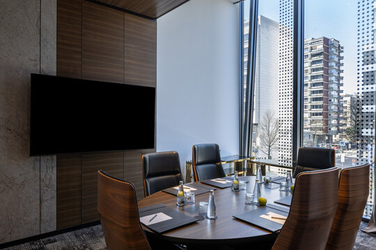 Executive round conference table in modern meeting room with city view