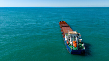 Distant aerial drone shot of an industrial freighter ship anchored far out in the ocean © Buğra Kaan Ersoy