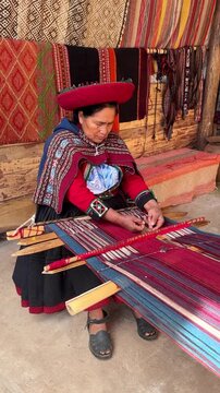 Peruvian woman weaving traditional colorful andean textile