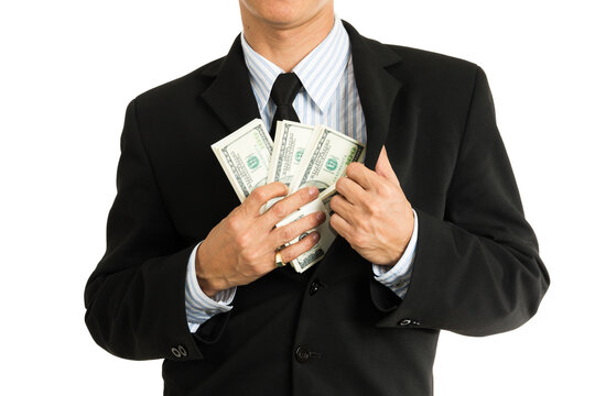 A businessman putting money in his pocket.