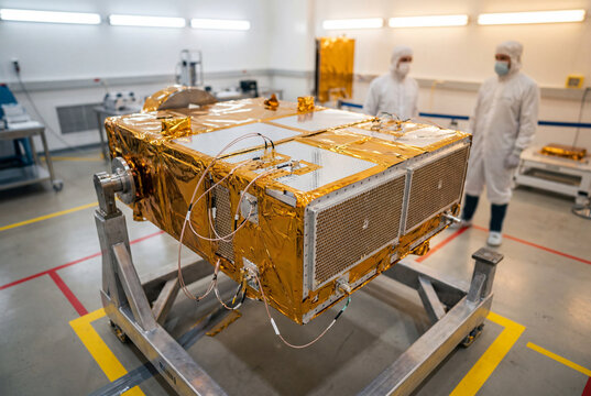 Satellite undergoing integration testing inside aerospace cleanroom laboratory