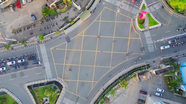 Aerial view of the busy Jalan Letnan Jendral Suprapto intersection with yellow box junction markings and surrounding traffic in Kecamatan Samarinda Ulu, Kalimantan Timur, Indonesia.