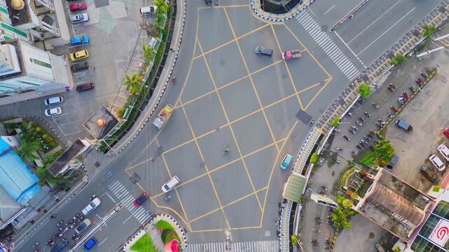 Aerial view of the yellow box junction on Jalan Letnan Jendral Suprapto with cars and motorcycles navigating the intersection in Kecamatan Samarinda Ulu, Kalimantan Timur, Indonesia.