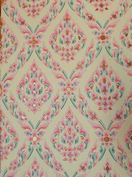 A full-frame shot of a Buddhist style wallpaper featuring a traditional, intricate pink and green floral pattern with gold accents.