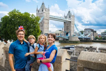 Family of four posing near Tower Bridge on the Thames in London © Sergey Novikov