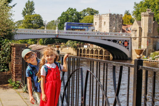 Kids at river Ouse near Lendal Bridge on background, York, UK
