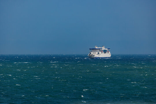 Ferry sails across English channel and blue ocean horizon line
