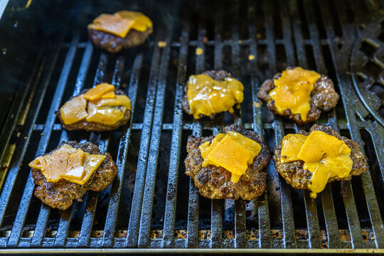Cheesburger auf einem Gasgrill mit Rindfleisch und K&auml;se &uuml;berbacken