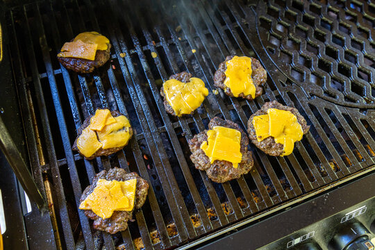 Cheesburger auf einem Gasgrill mit Rindfleisch und K&auml;se &uuml;berbacken