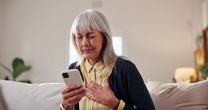 Heart attack, home and senior woman with phone, discomfort and communication with emergency service. Healthcare, request and elderly person with chest pain, typing and message on mobile in house