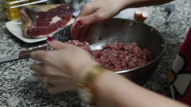  Mujer mayor mezclando ingredientes de alb&oacute;ndigas a mano en un taz&oacute;n. Abuela mayor amasando y mezclando ingredientes de alb&oacute;ndigas a mano en un taz&oacute;n. Cocina tradicional casera, aut&eacute;ntica senior.