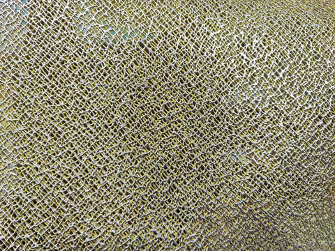 An elegant golden metallic mesh texture background with intricate interlaced patterns, showing a shiny embossed surface and detailed woven design ideal for modern creative luxury backdrops.