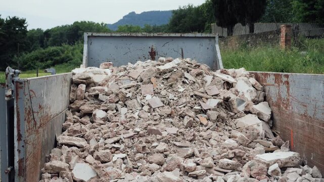 Close-up of a large pile of broken concrete, stones and construction debris inside a waste container. Construction waste and demolition concept. High quality 4k footage
