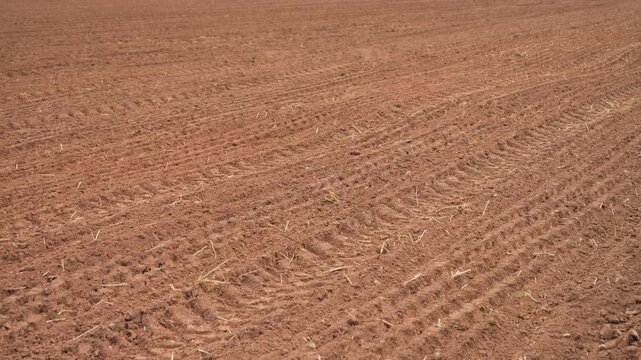 Freshly plowed farmland with furrows stretching across the landscape. Agriculture and rural farming concept. High quality 4k footage