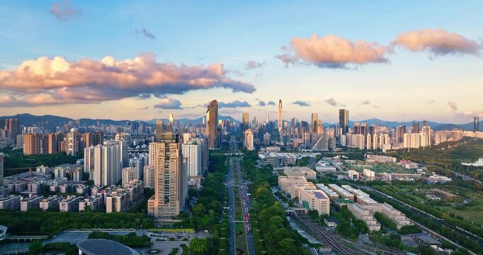 Aerial view of modern city skyline and lush green urban road at sunset in Shenzhen, China