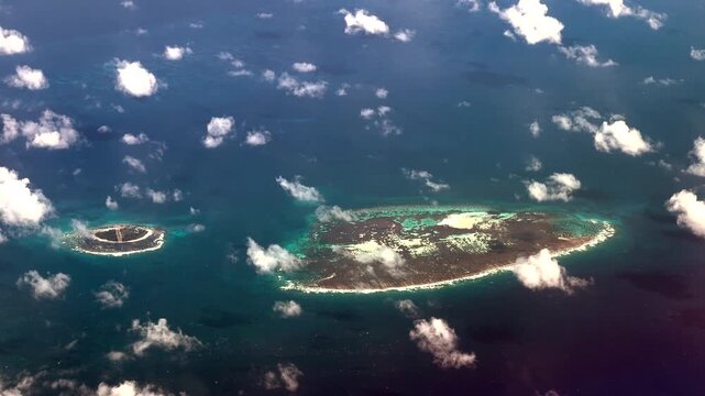 4k aerial landscape video footage flying along R&eacute;mire Island (left) and Remire Reef (right) as part of the Amirante Islands group in the territory of Seychelles, located in Indian Ocean