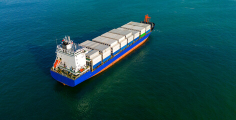 Diagonal aerial drone view of a blue and white commercial cargo ship on the ocean © Buğra Kaan Ersoy