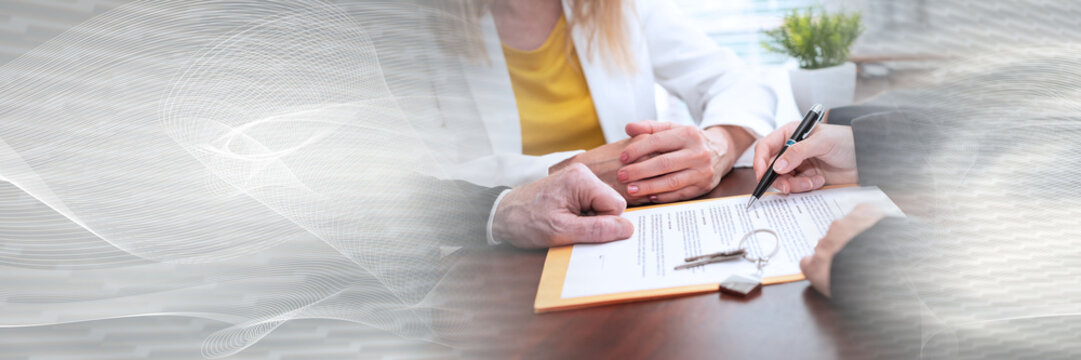 Realtor giving explanation to a couple about terms of investment contract (lorem ipsum text used); panoramic banner