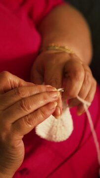 Woman's hands crocheting white yarn piece with hook close up. Handmade crafts, hobbies, slow living, and textile arts concepts.