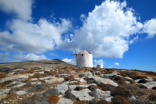 Rural landscape with scenic view of old traditional stone windmills in the countryside of Amorgos island in Cyclades Greece.