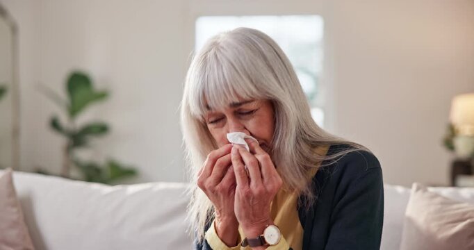 Tissue, sneeze or old woman blowing nose in home with influenza, health problem and virus symptoms. Sick, senior person and allergies in living room with toilet paper, hayfever and sinus infection.