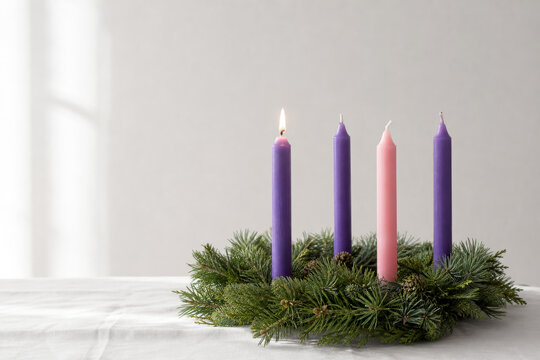 Simple Advent wreath with one softly lit candle on white linen.