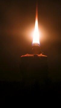 Glowing oil lamp flame burning in absolute darkness 4K