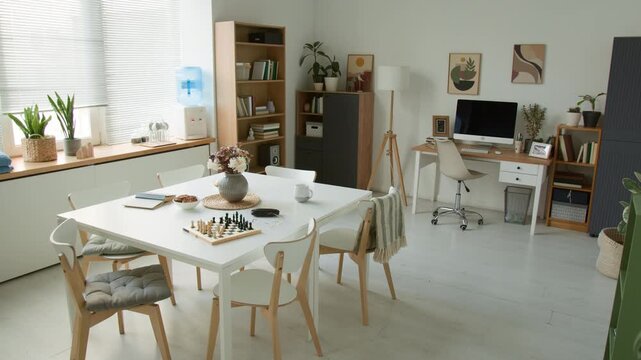 Wide angle shot of empty modern common room in retirement home featuring chess board on table and computer desk. Clip for marketing senior living facilities or real estate