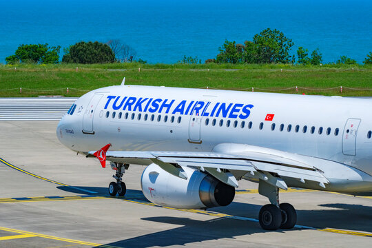 Close up of Turkish Airlines fuselage and underwing jet engine on tarmac