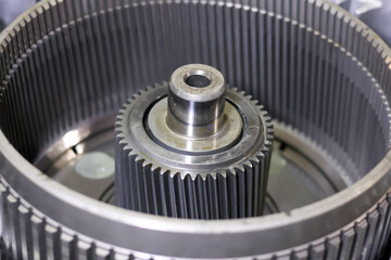 Close up view of a metallic automatic gearbox component showing an internal planetary ring gear drum with center sun gear spline assembly. © Jumain