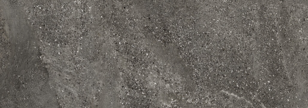 Black terrazzo texture with natural stone particles and beach sand inspired earthy surface pattern. Rustic architectural background with warm neutral tones.