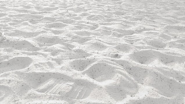 Textured White Sand Beach Surface with Footprints