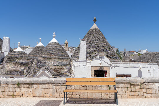 Traditional trulli stone houses with bench in Alberobello, Puglia, Italy