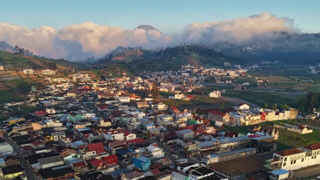 Aerial view of Bukit Skoter overlooking the town of Kecamatan Batur with its mosque and surrounding hills in the morning light in Kecamatan Batur, Jawa Tengah, Indonesia.
