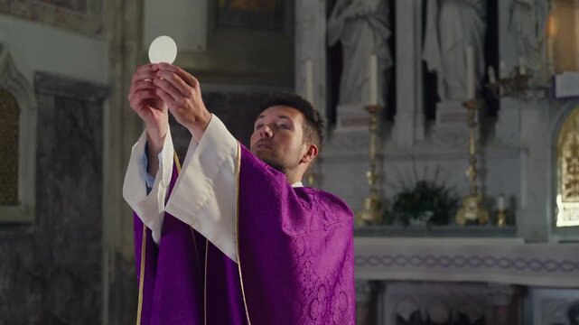 Elevation of the Host during the Consecration in a Catholic Mass, the priest raising the Eucharistic bread after speaking the words