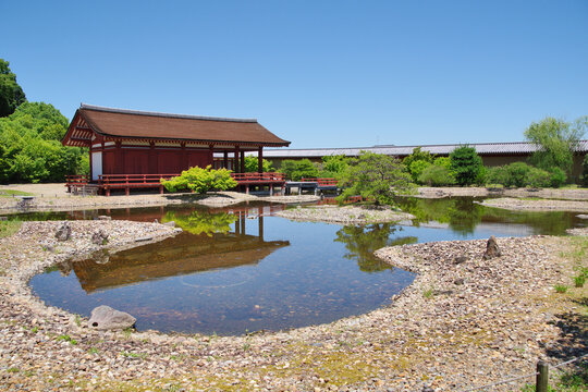 Ancient japanese imperial palace site in Nara, Japan. Traditional Japanese building by a tranquil pond at Heijo Palace Remains.