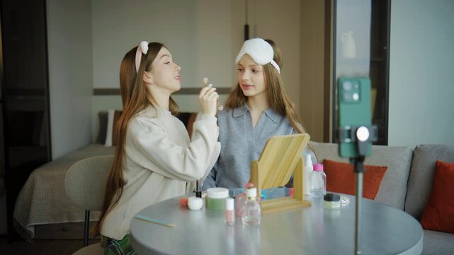 Teenagers share a makeup session at home while preparing for a video on social media