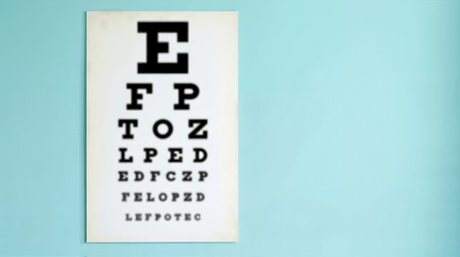 Blurry Snellen eye chart hanging on a light blue wall. Visual simulation of impaired vision or myopia. Optometry exam and ophthalmology concept