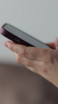 Vertical video Hand of woman using texting mobile phone or chat. Close up of woman hand.