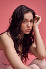 Fototapeta premium Young beautiful woman showcasing delicate pastel fashion in a vibrant setting