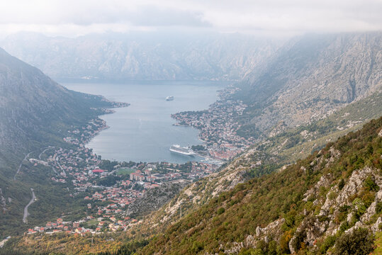 View from cable car to Boka Kotor Bay, large tourist liner parked among mountain