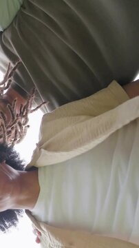 Vertical video: Laughing five friends leaning over camera outdoors, cam filming red shirt for fun