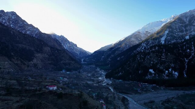 Scenic Aerial View of Sangla Valley Surrounded by Himalayan Mountains with Green Forests, Flowing River, Beautiful Village Landscape, Snow Peaks, Cloudy Sky and Breathtaking Himalayan Nature Scenery