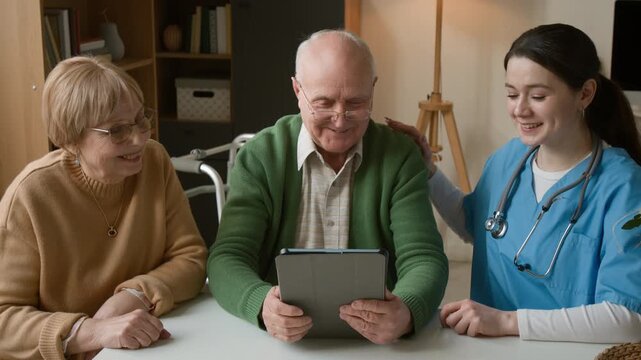 Senior couple and young female nurse using digital tablet in assisted living facility. Clip promoting senior care services, digital literacy, and telehealth technology